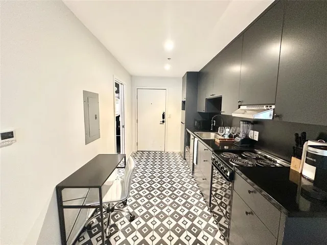 a kitchen with a sink cabinets and wooden floor