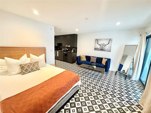 a bedroom with a bed and a view of living room