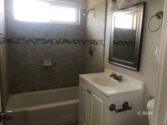 1505 South McCall Street Ridgecrest, CA 93555 - Photo 10 of 17 a bathroom with a sink and mirror with bathtub