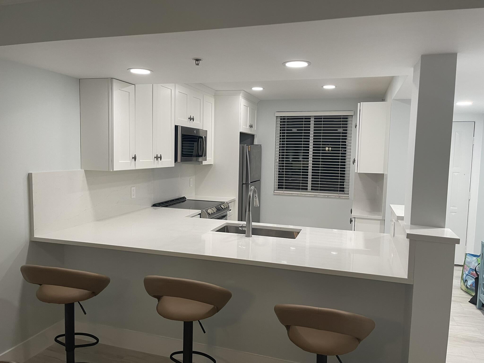 401 South Seas Drive, Unit 503 Jupiter, FL 33477 - Photo 3 of 11 a kitchen with stainless steel appliances a sink and a refrigerator
