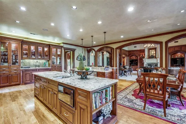 a living room with stainless steel appliances granite countertop table chairs and a rug