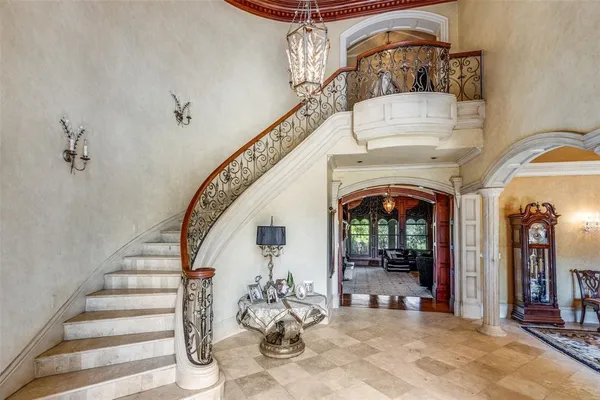 a view of a hallway with entryway chandelier and windows