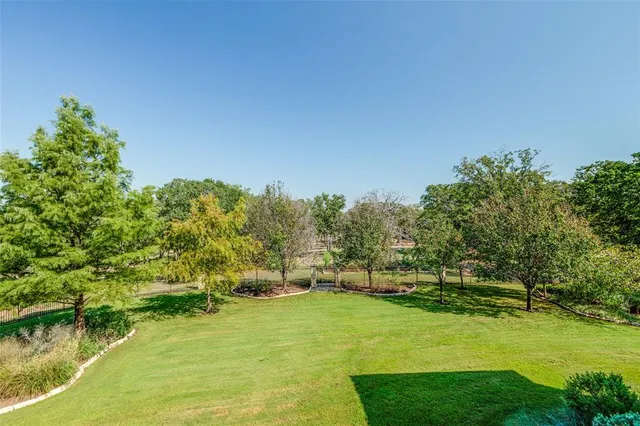 a view of a house with a big yard and large trees