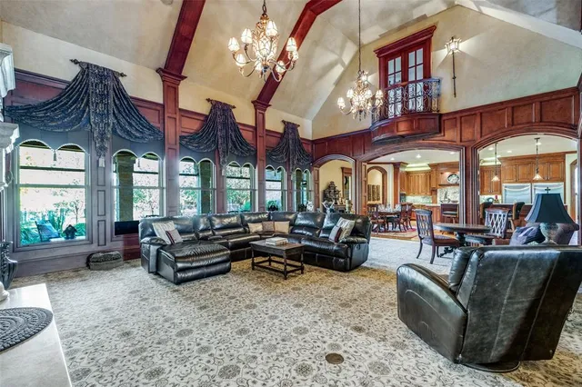 a living room with furniture a large window and a chandelier