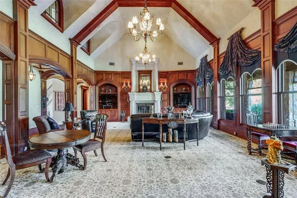 a view of a dining room with furniture chandelier and a fireplace