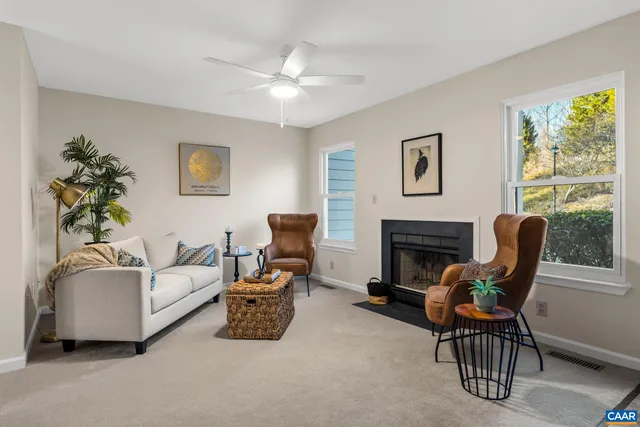 a living room with furniture a fireplace and a large window