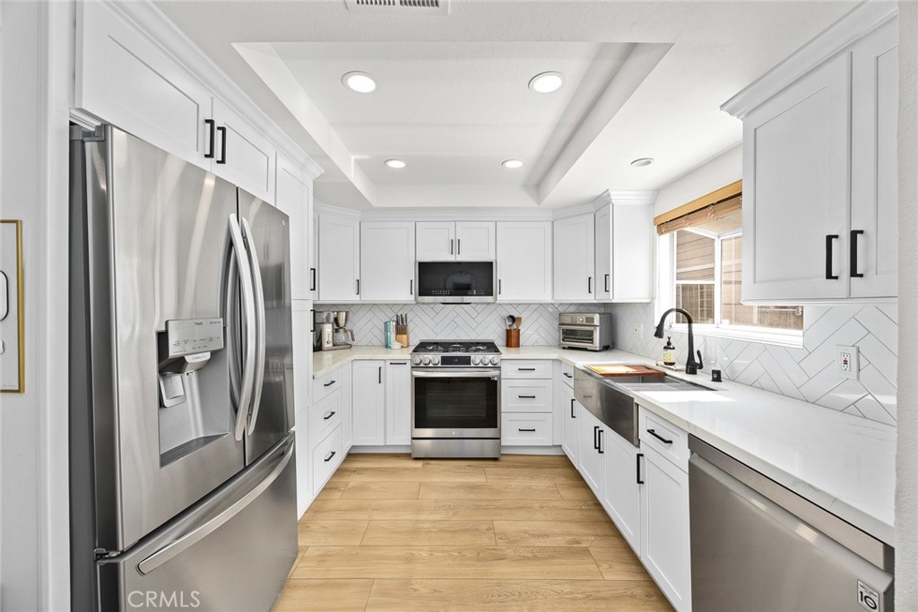 154 North Meridith Avenue, Unit 8 Pasadena, CA 91106 - Photo 14 of 31 a large kitchen with stainless steel appliances granite countertop a stove top oven a refrigerator a sink and dishwasher