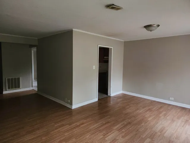 a view of an empty room with wooden floor