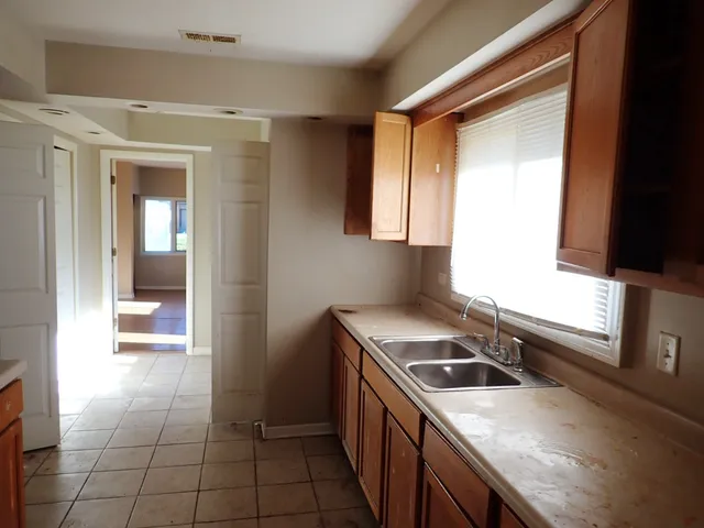 a kitchen that has a sink a stove and a microwave