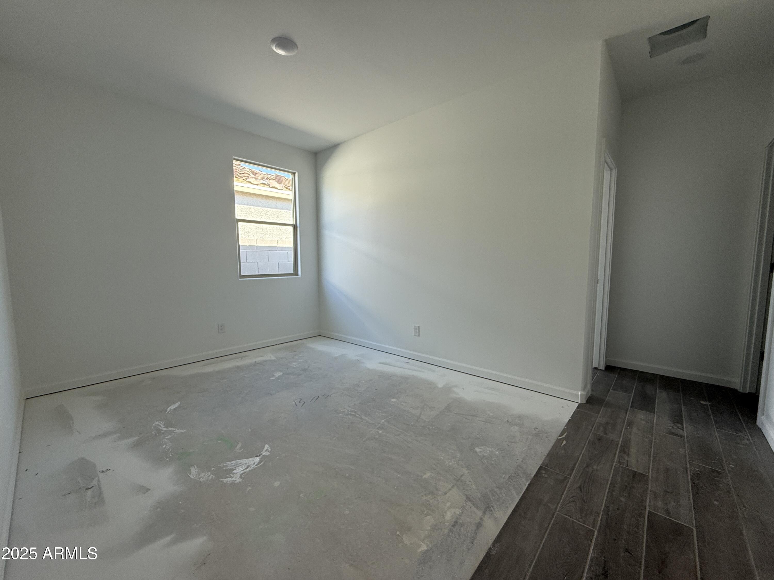 9627 West Tamarisk Avenue Tolleson, AZ 85353 - Photo 21 of 42 a view of an empty room with wooden floor and a window