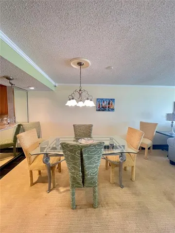 a room with table chairs and a chandelier