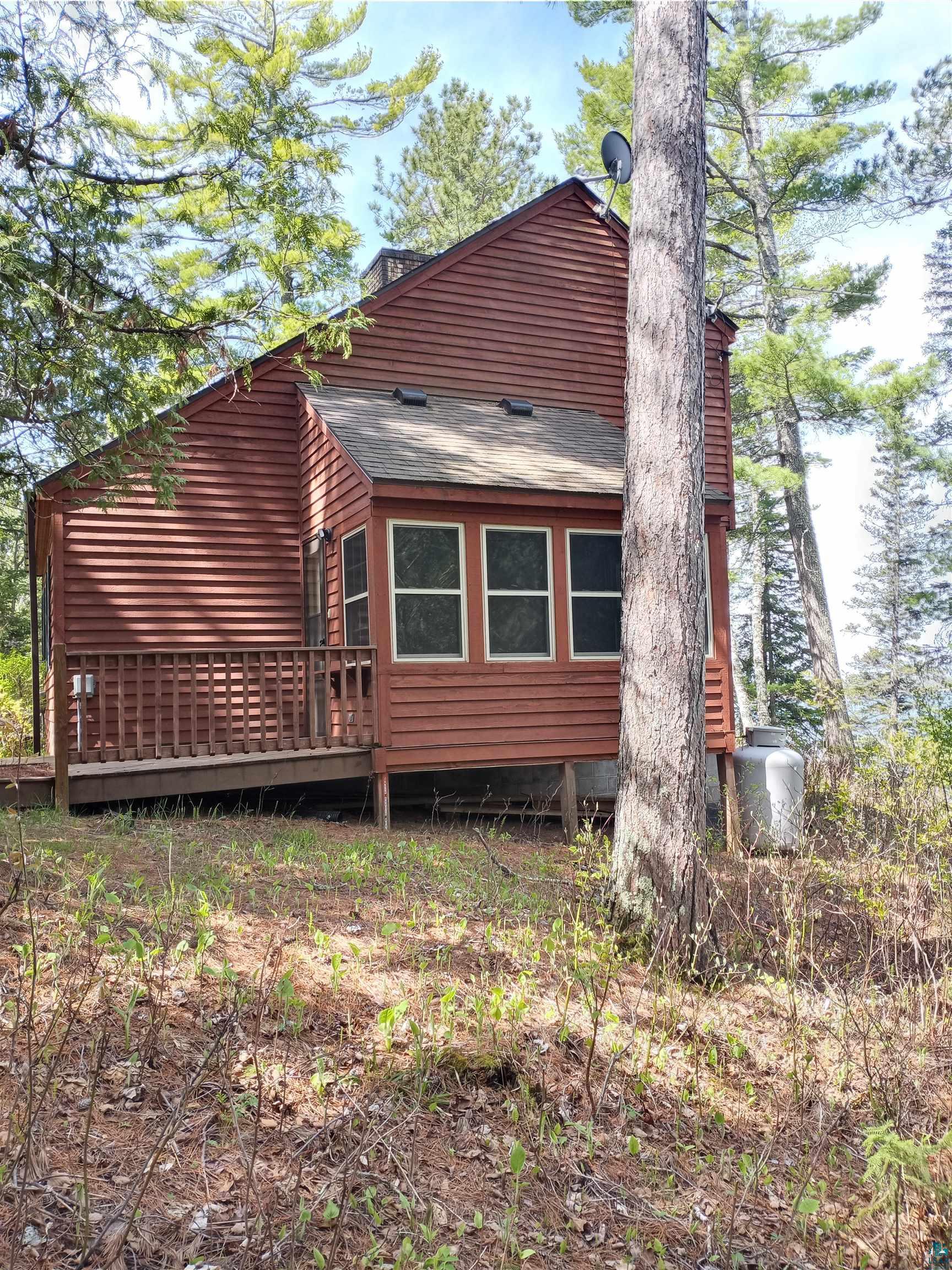 View of side of property featuring a wooden deck