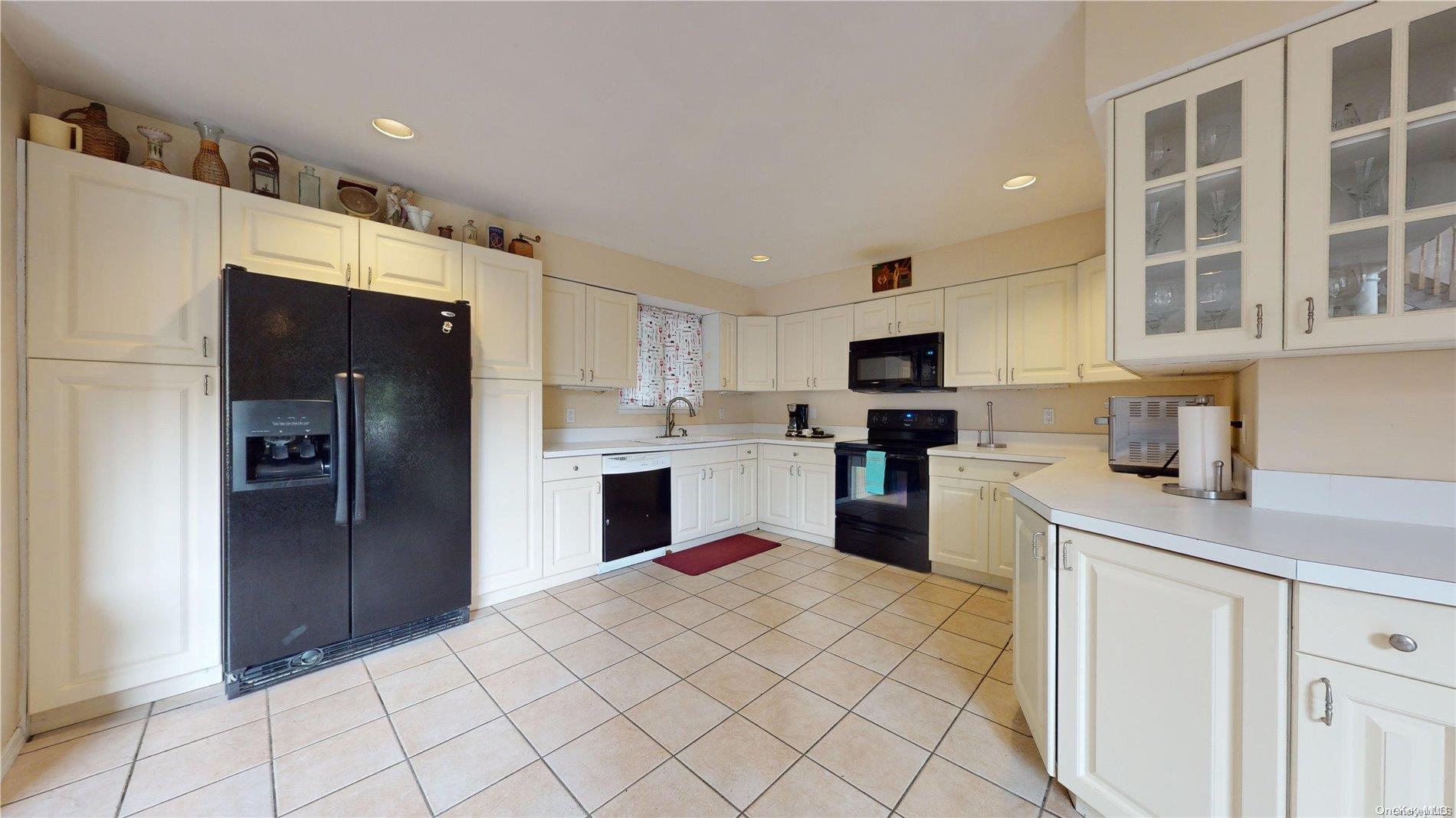 28 Club Lane Remsenburg, NY 11960 - Photo 7 of 33 a kitchen with stainless steel appliances kitchen island granite countertop a refrigerator oven a sink dishwasher and white cabinets with wooden floor