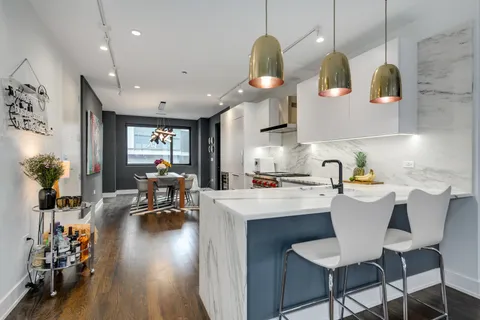 a kitchen with a sink a stove and chairs