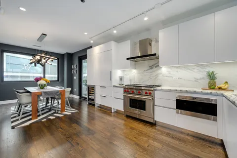 a kitchen with stainless steel appliances kitchen island granite countertop a stove a sink and a refrigerator