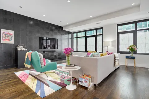 a living room with furniture large window and wooden floor