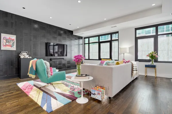 a living room with furniture large window and wooden floor