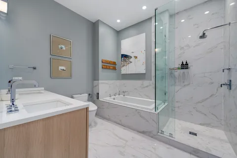 a bathroom with a tub sink shower and mirror