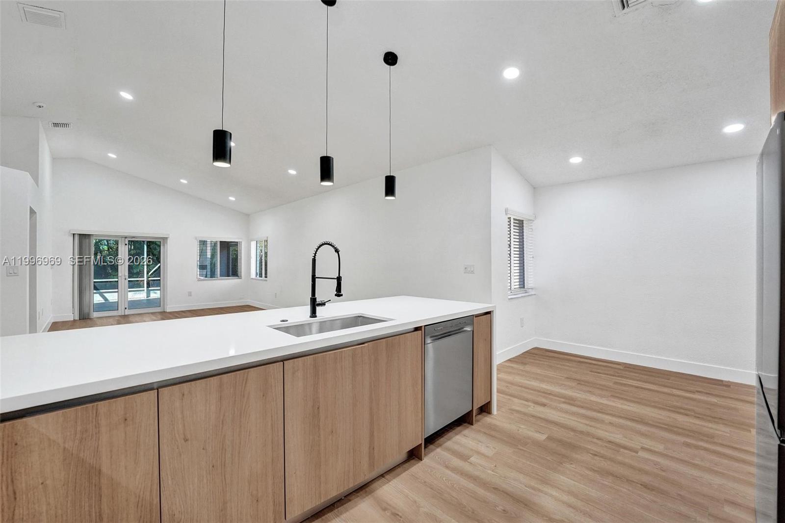 10153 Northwest 3rd Court Plantation, FL 33324 - Photo 25 of 82 a kitchen with stainless steel appliances granite countertop a sink a oven and a large window with wooden floor