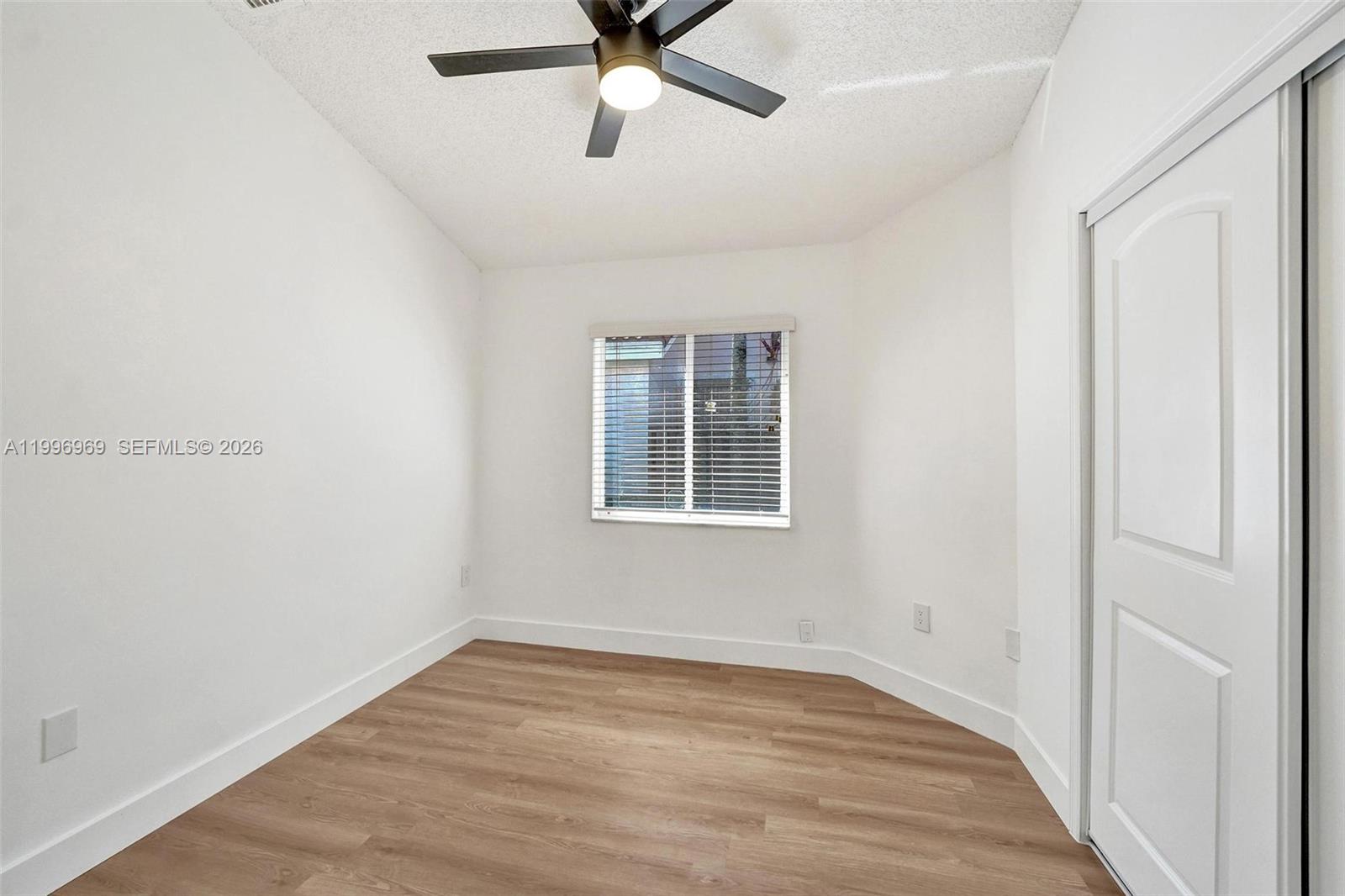 10153 Northwest 3rd Court Plantation, FL 33324 - Photo 56 of 82 a view of an empty room with wooden floor and a window