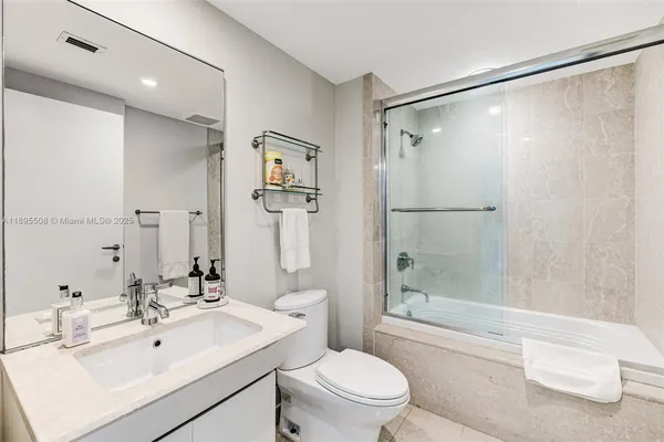 a bathroom with a sink mirror shower and toilet
