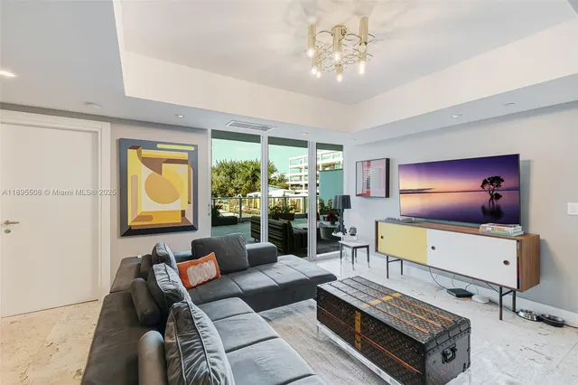 a living room with furniture a chandelier and a flat screen tv