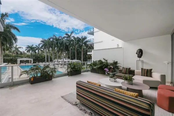 a view of a patio with couches table and chairs with potted plants and big yard
