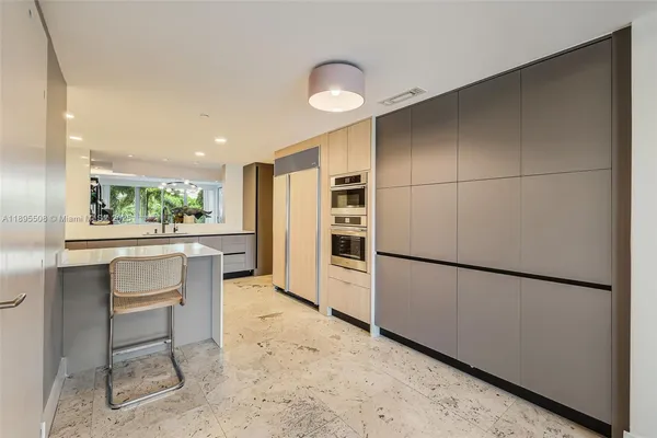 a kitchen with a refrigerator a dining table and chairs