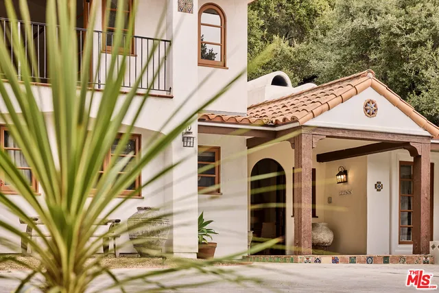 a front view of a house with a tree