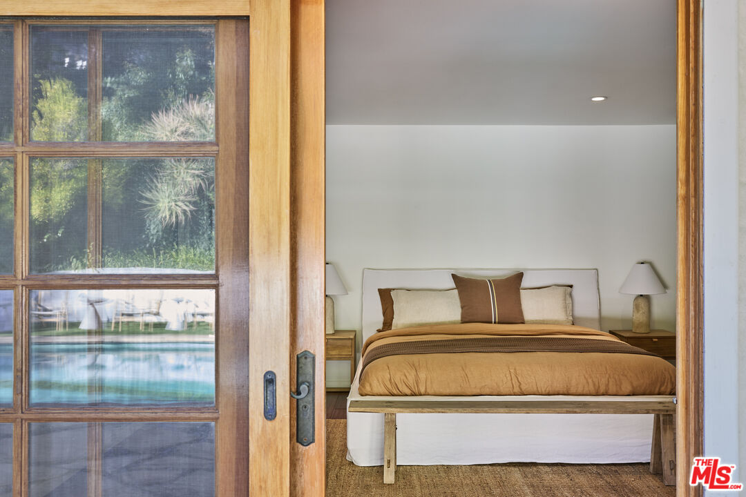 3268 Serra Road Malibu, CA 90265 - Photo 17 of 24 a bedroom with a bed and a window