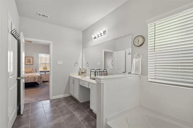 a bathroom with a tub a sink and mirror