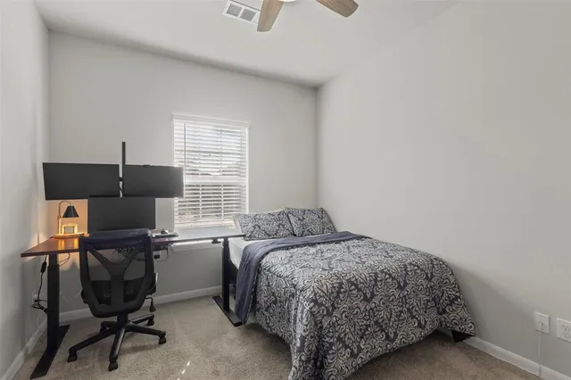 a bedroom with a bed and a computer on a desk