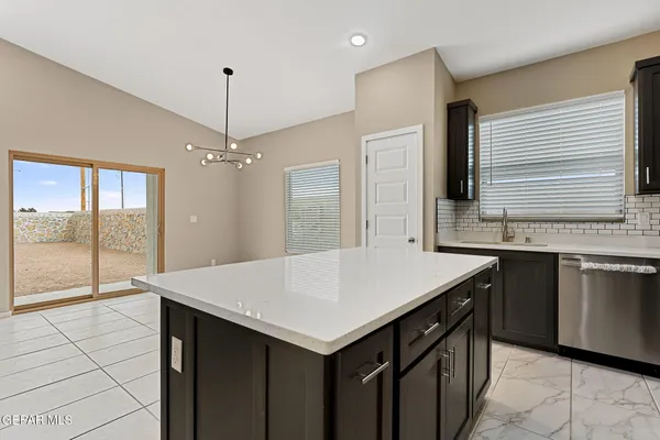a kitchen with a stove a refrigerator a sink and dishwasher with wooden floor