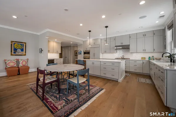 a living room with furniture and a dining table with kitchen view