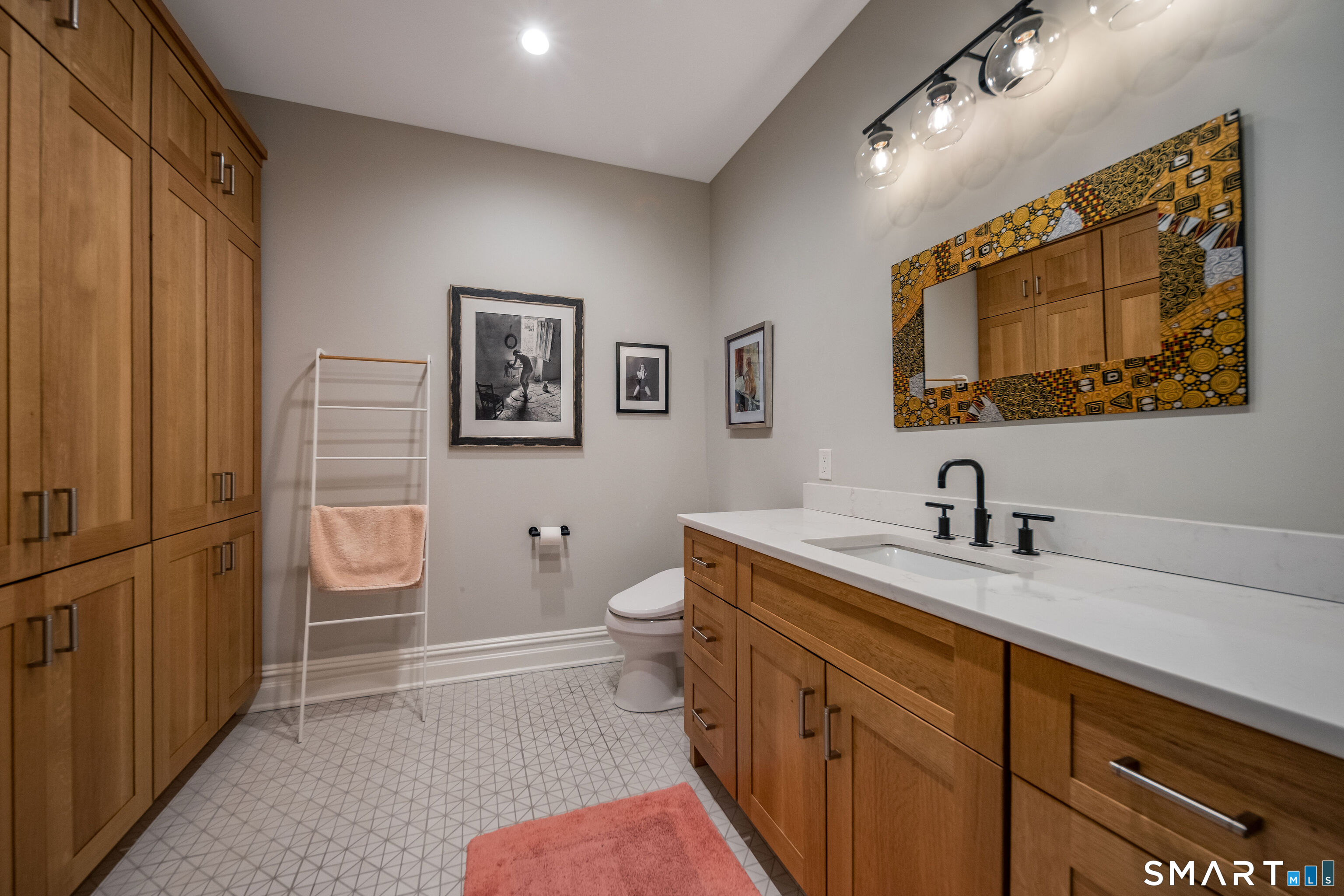 66 High Street, Unit 34 Guilford, CT 06437 - Photo 24 of 40 a spacious bathroom with a granite countertop sink mirror vanity and toilet