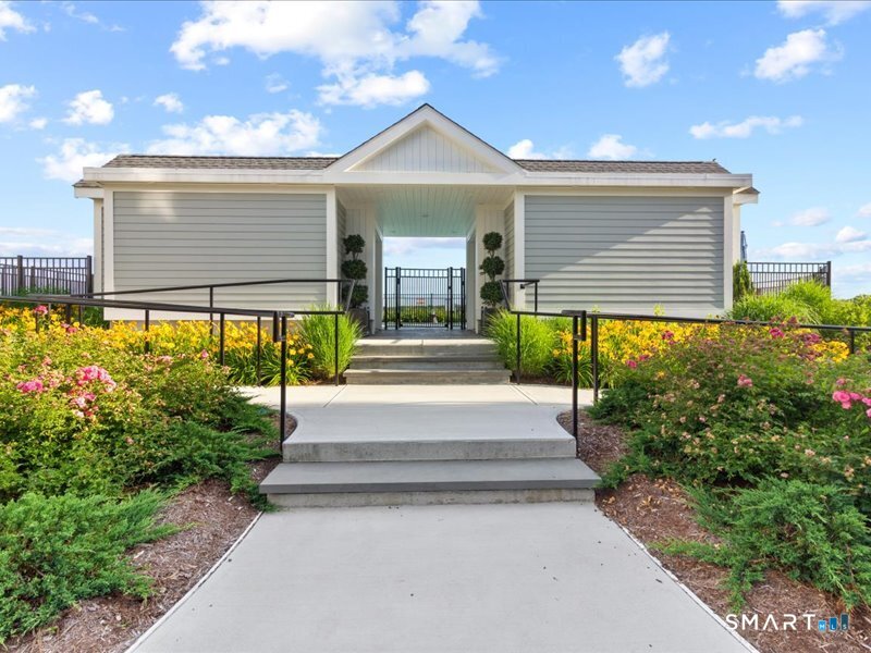 66 High Street, Unit 34 Guilford, CT 06437 - Photo 34 of 40 a front view of a house with a yard and potted plants