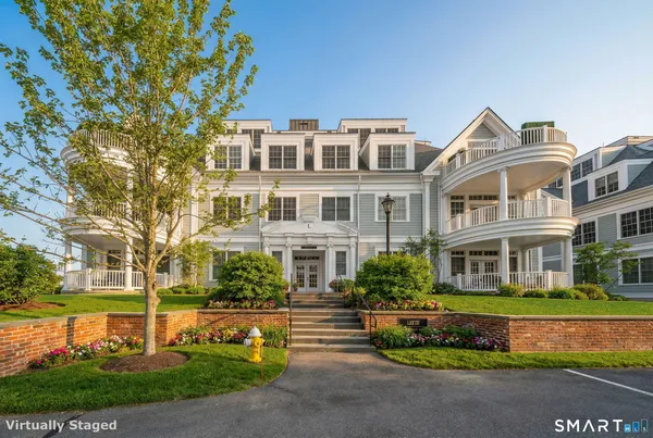 a kitchen with stainless steel appliances kitchen island granite countertop a table chairs sink and cabinets