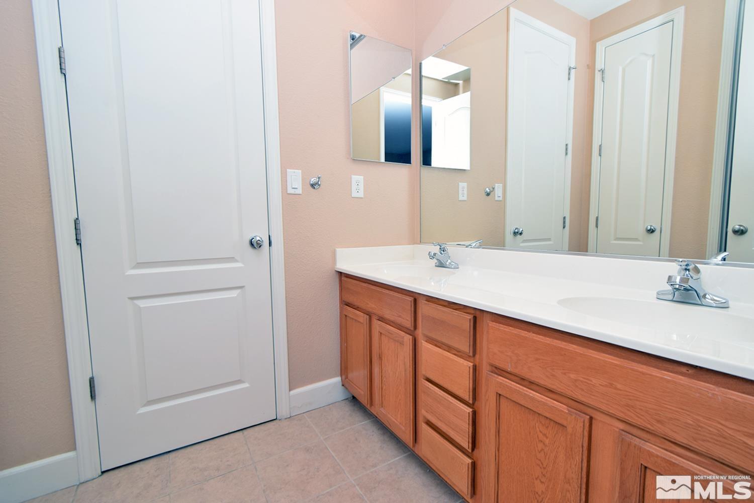 410 Teramo Court Reno, NV 89521 - Photo 17 of 32 a bathroom with a double vanity sink and mirror