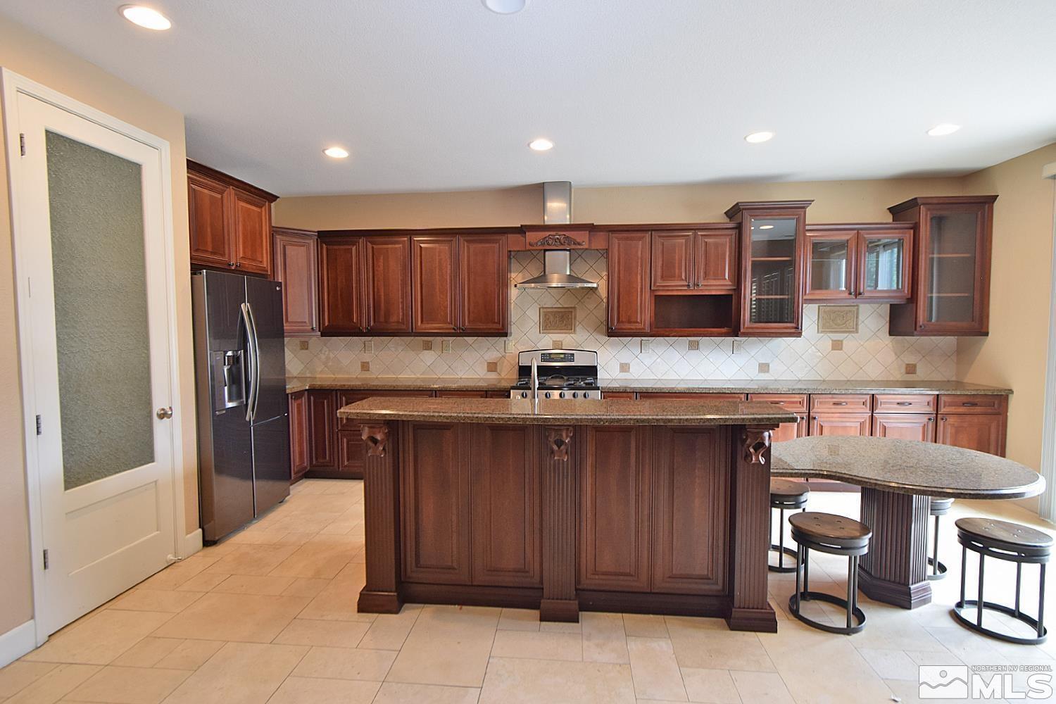 410 Teramo Court Reno, NV 89521 - Photo 4 of 32 a kitchen with stainless steel appliances granite countertop a refrigerator and a stove