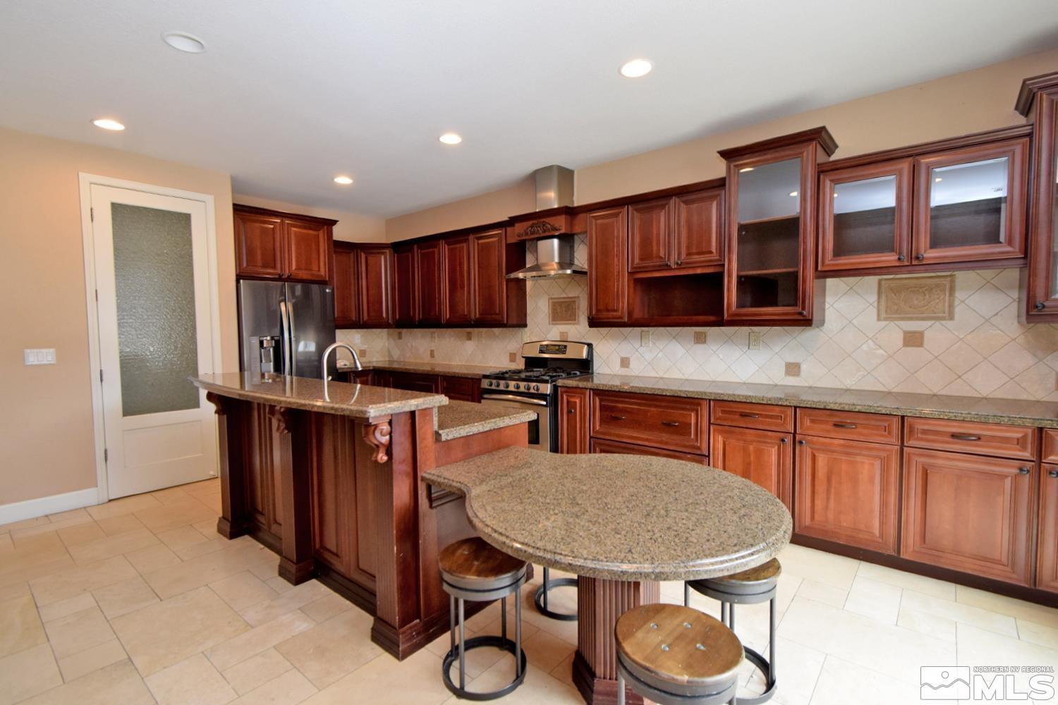 410 Teramo Court Reno, NV 89521 - Photo 6 of 32 a kitchen with granite countertop a sink cabinets and appliances