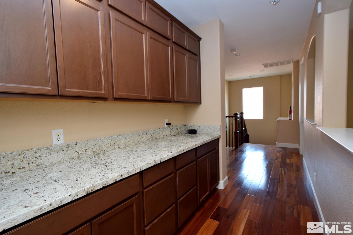 410 Teramo Court Reno, NV 89521 - Photo 10 of 32 a kitchen with granite countertop wooden cabinets a sink and dishwasher