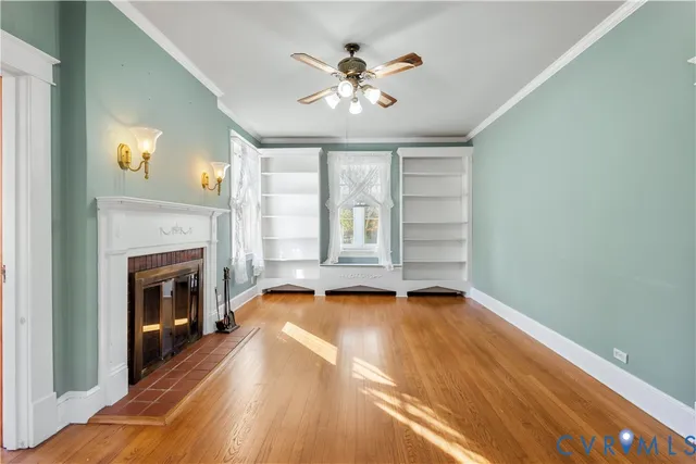a view of an empty room with window and fire place