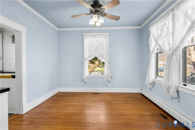 an empty room with windows fireplace and wooden floor
