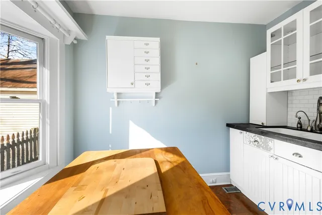 a view of a big room with wooden floor and windows