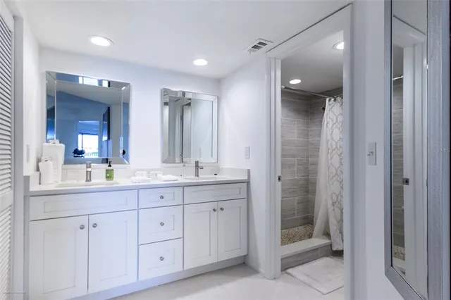 a bathroom with a double vanity sink mirror and shower