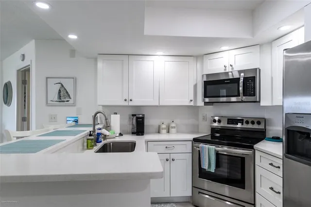 a kitchen with refrigerator a microwave and cabinets