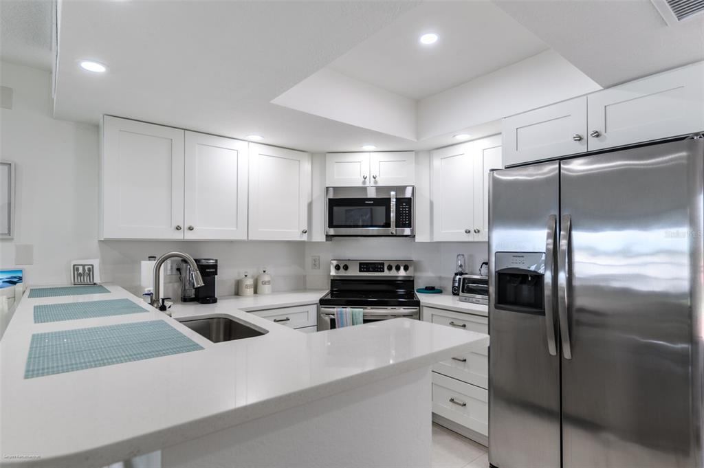 2601 West Marion Avenue, Unit 41C Punta Gorda, FL 33950 - Photo 9 of 43 a kitchen with refrigerator a microwave and cabinets