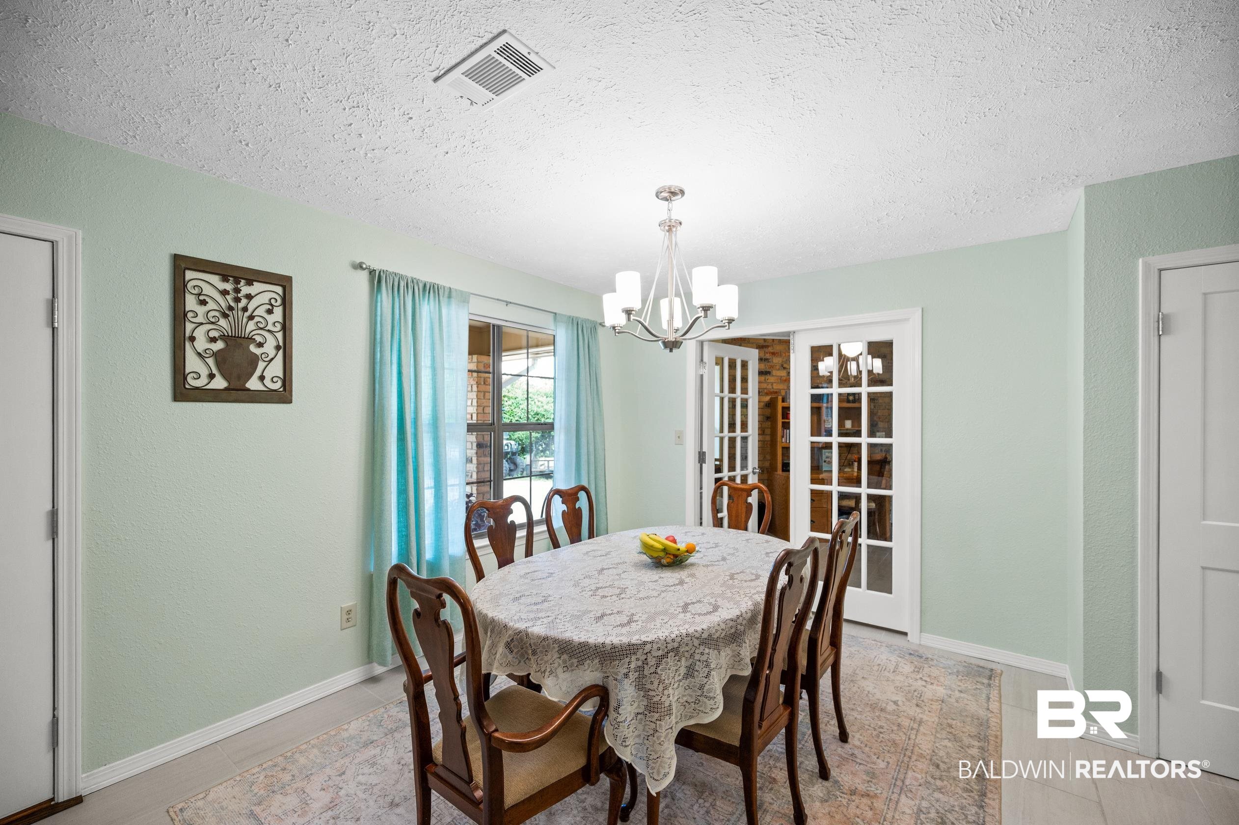 2772 Santa Rosa Circle Lillian, AL 36549 - Photo 11 of 50 Dining room with an inviting chandelier, a textured ceiling, and light tile patterned flooring