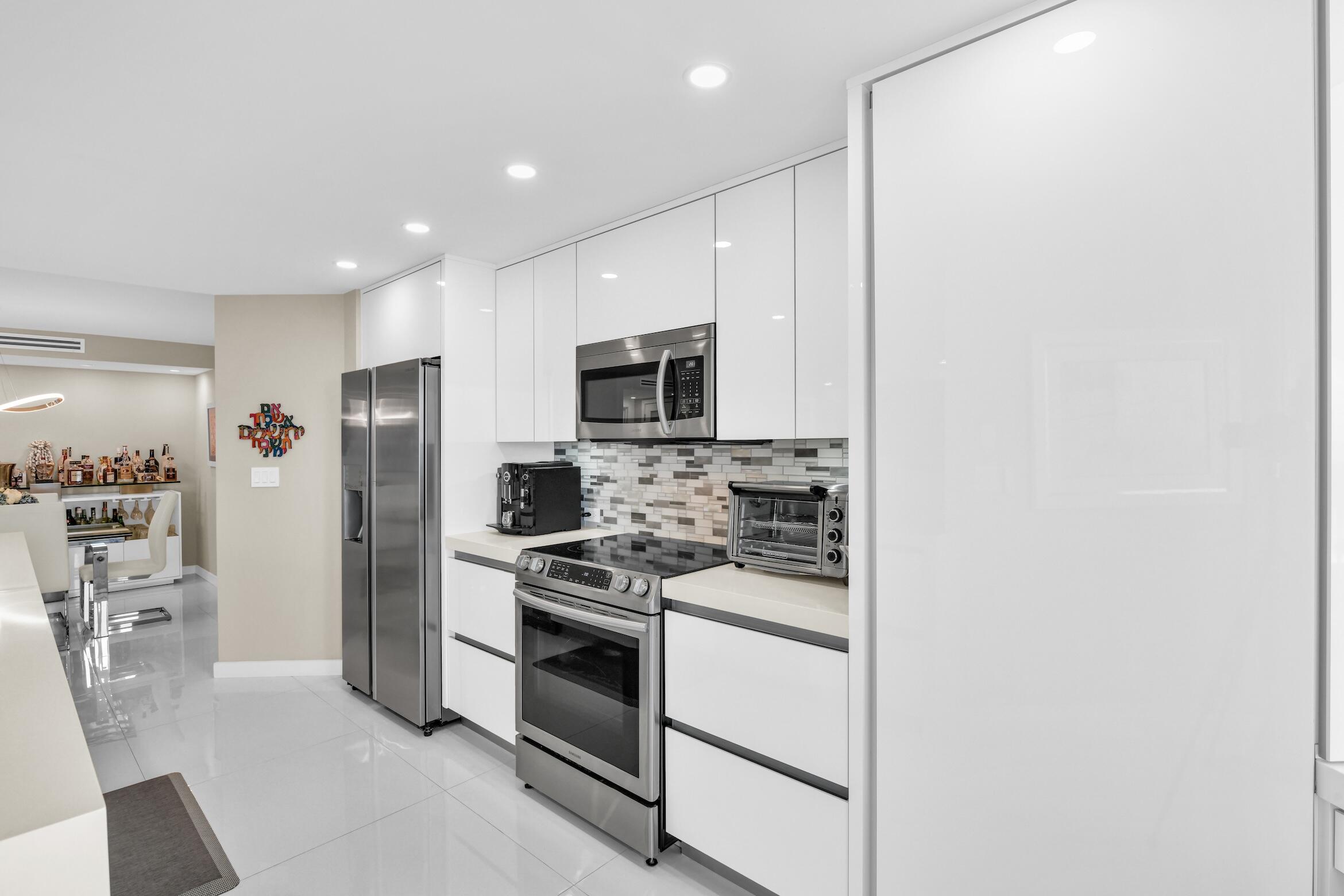550 South Ocean Boulevard, Unit 605 Boca Raton, FL 33432 - Photo 11 of 51 a kitchen with stainless steel appliances a refrigerator stove and microwave