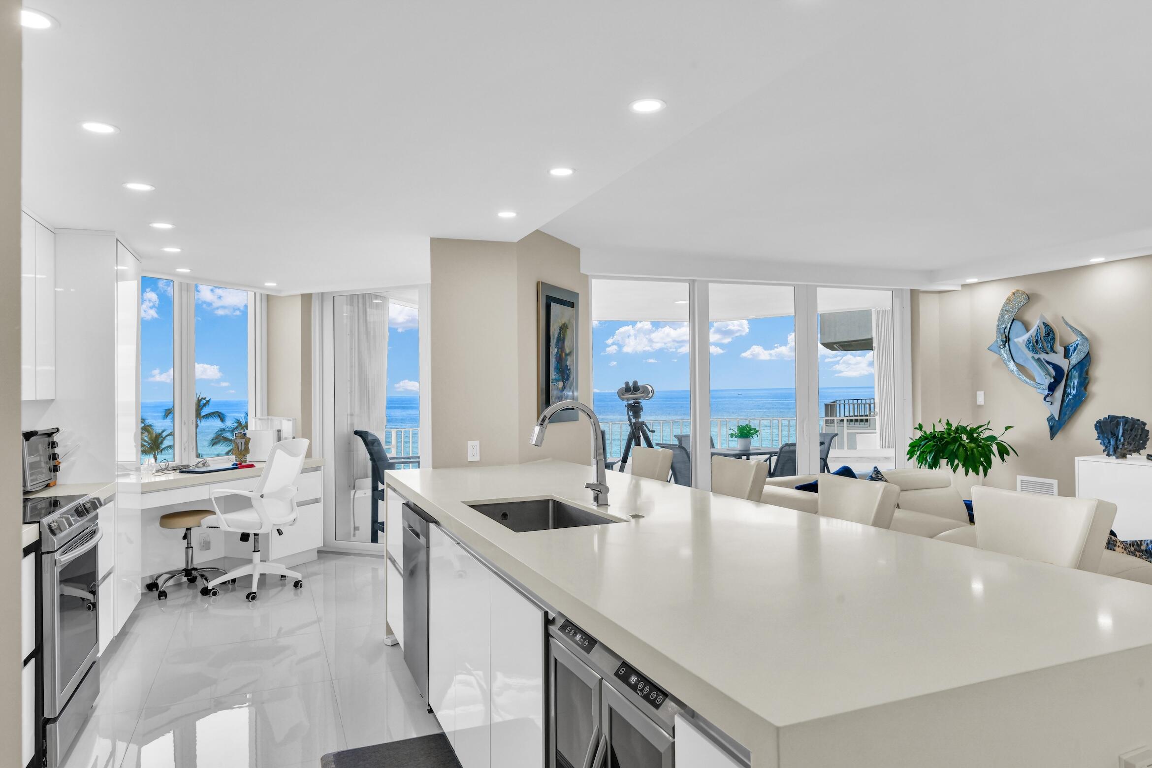 550 South Ocean Boulevard, Unit 605 Boca Raton, FL 33432 - Photo 8 of 51 a large white kitchen with a large window and stainless steel appliances